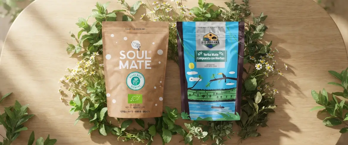 Pachete tip „doypack” cu yerba mate pe bază de plante, cu mentă și plante aromatice, într-o compoziție naturală, pe un fundal din lemn.